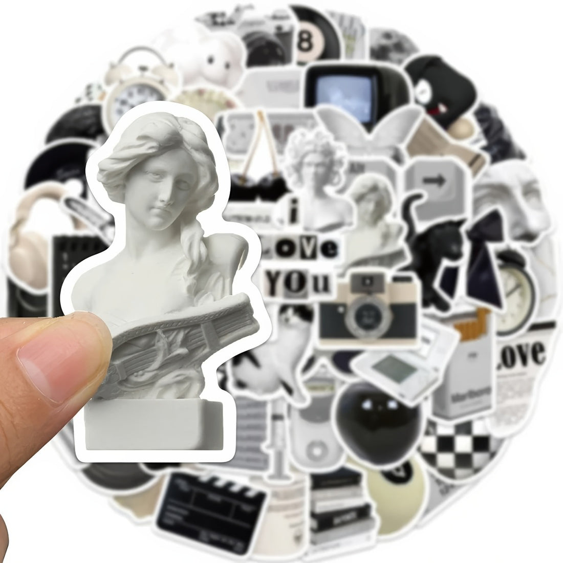 A large assortment of black and white stickers featuring vintage sculptures, retro tech, checkerboards, cats, milk cartons, and 8-ball designs, arranged aesthetically for decoration.