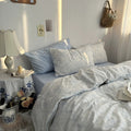 White duvet cover set with light blue floral line art and matching pillowcases styled in a cozy vintage-inspired bedroom.