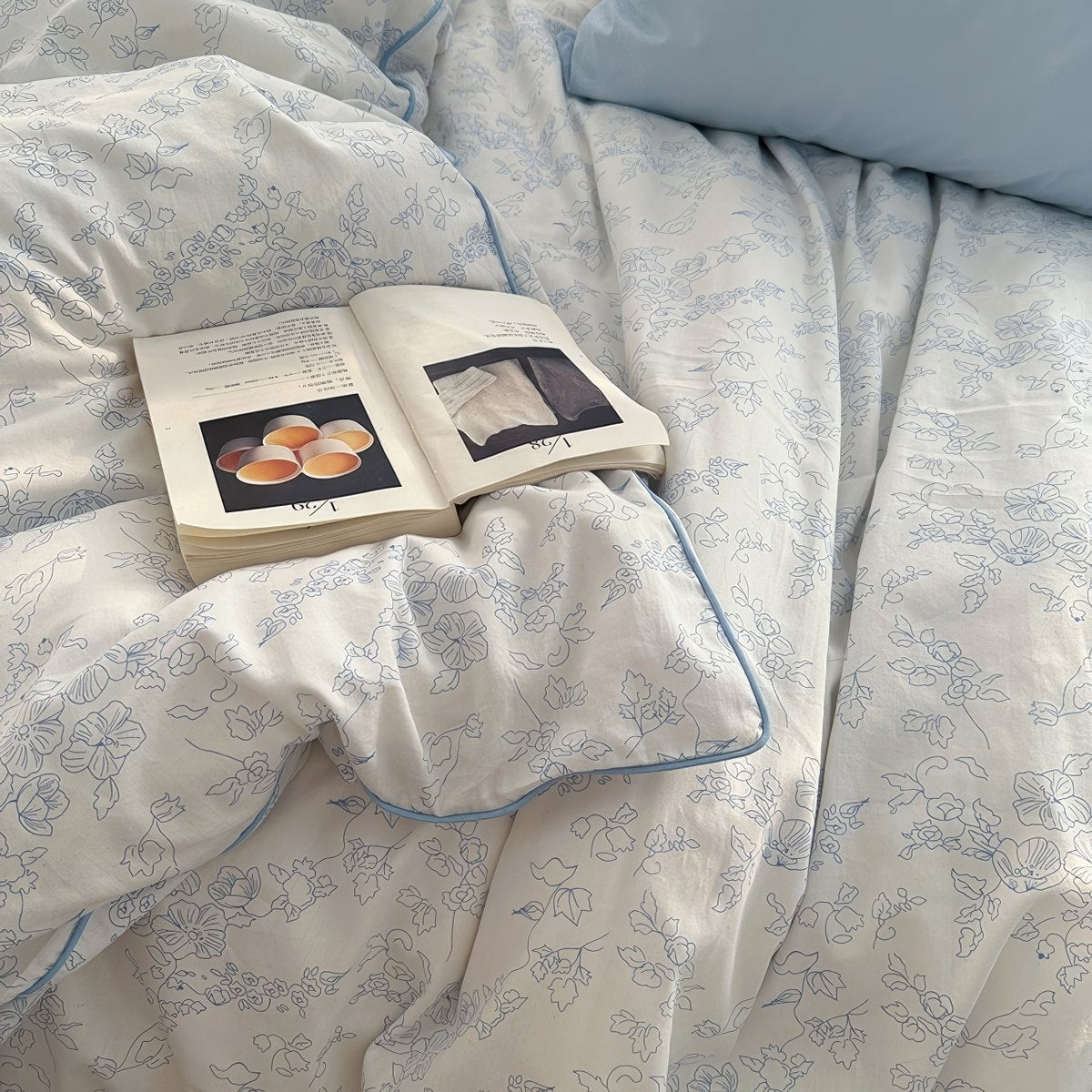 White duvet cover set with light blue floral line art and matching pillowcases styled in a cozy vintage-inspired bedroom.