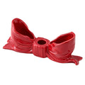 Ceramic bow-shaped candle holder in pink, red, and white with a glossy finish, designed to hold taper candles; decorative and elegant for home decor.