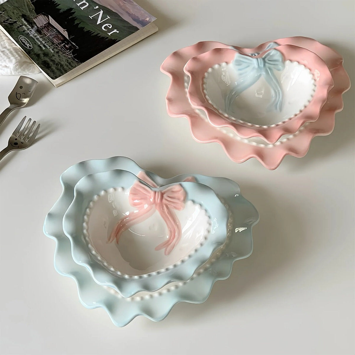 A pastel-colored, heart-shaped ceramic plate featuring scalloped edges, embossed hearts, and an elegant bow accent. Available in soft pink, pastel blue, and delicate yellow colors.