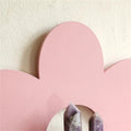 pink flower-shaped wall shelf with six rounded petals and a semi-circular shelf in the center