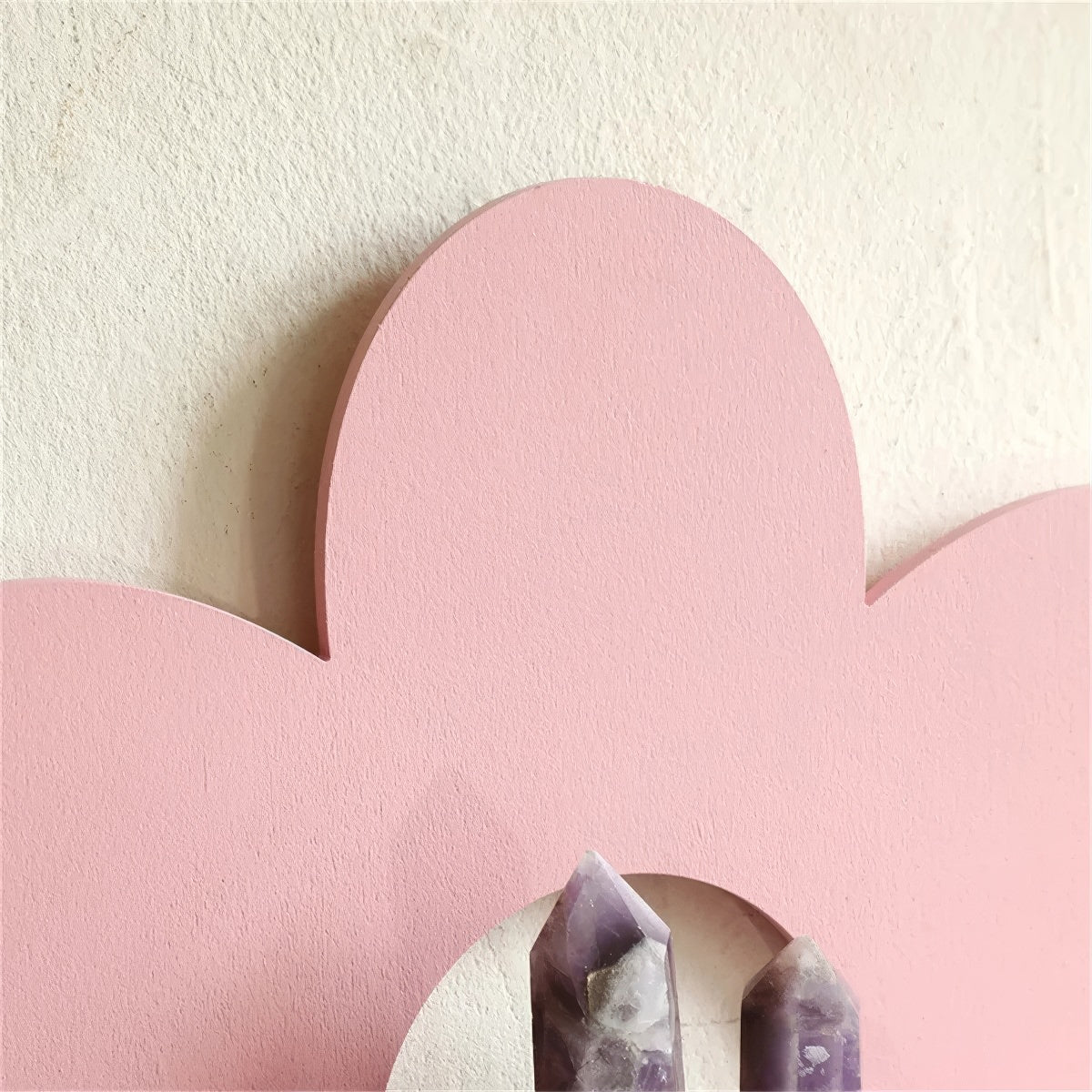 pink flower-shaped wall shelf with six rounded petals and a semi-circular shelf in the center
