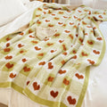 Heart-patterned blanket draped over a bed