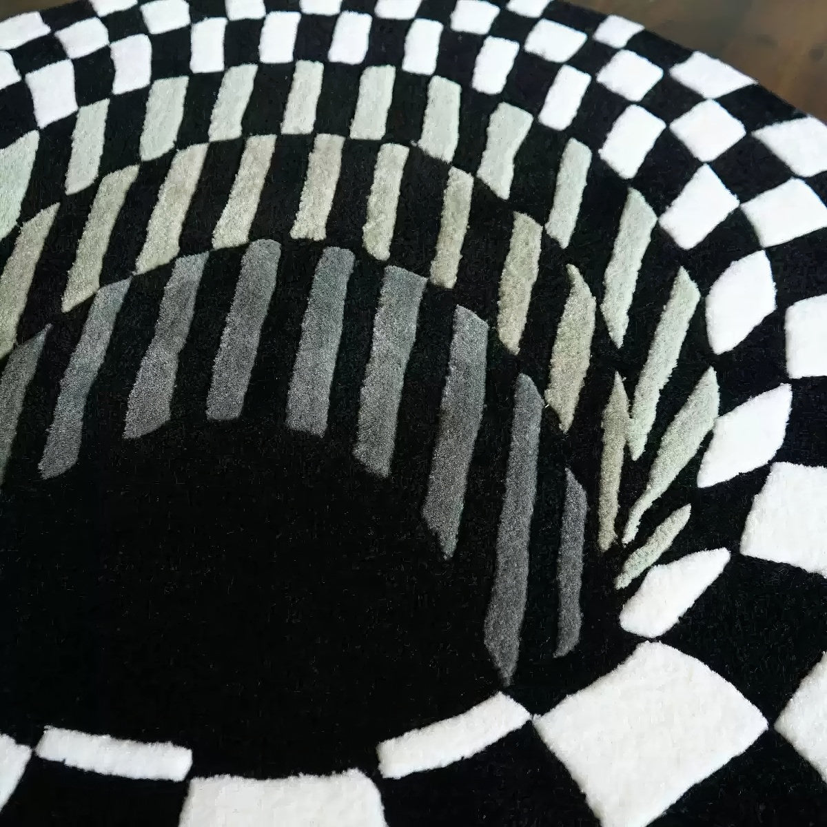 black and whiite 3d effect illusion rug looking like a hole or tunnel with checkered pattern