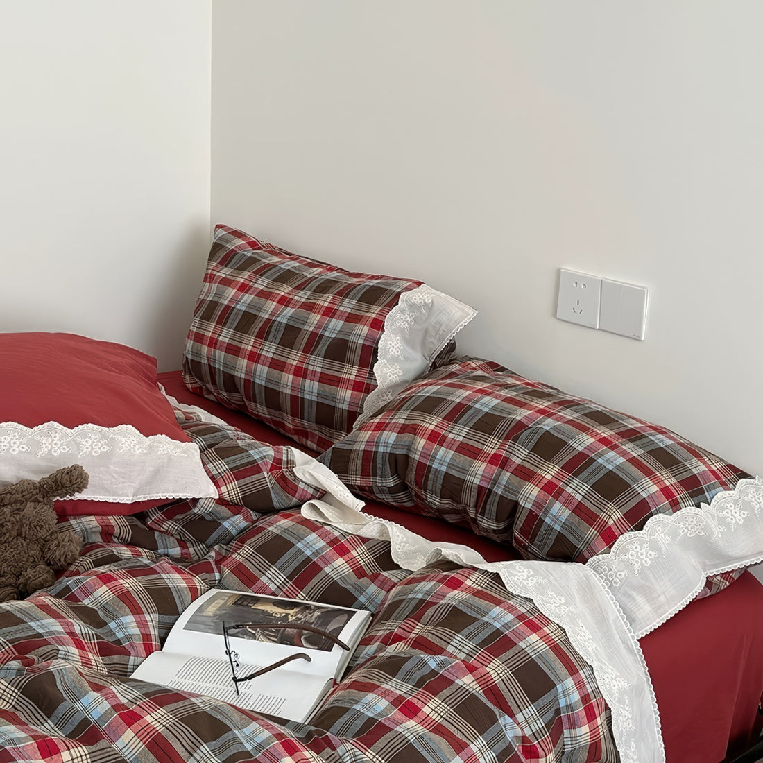 Bavarian plaid bedding set with red and brown checks and white lace ruffled trim on duvet cover and pillowcases.