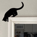 Black cat silhouette decal on a white wall above a door