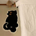 Black cat-shaped tufted rug with white border on a white background