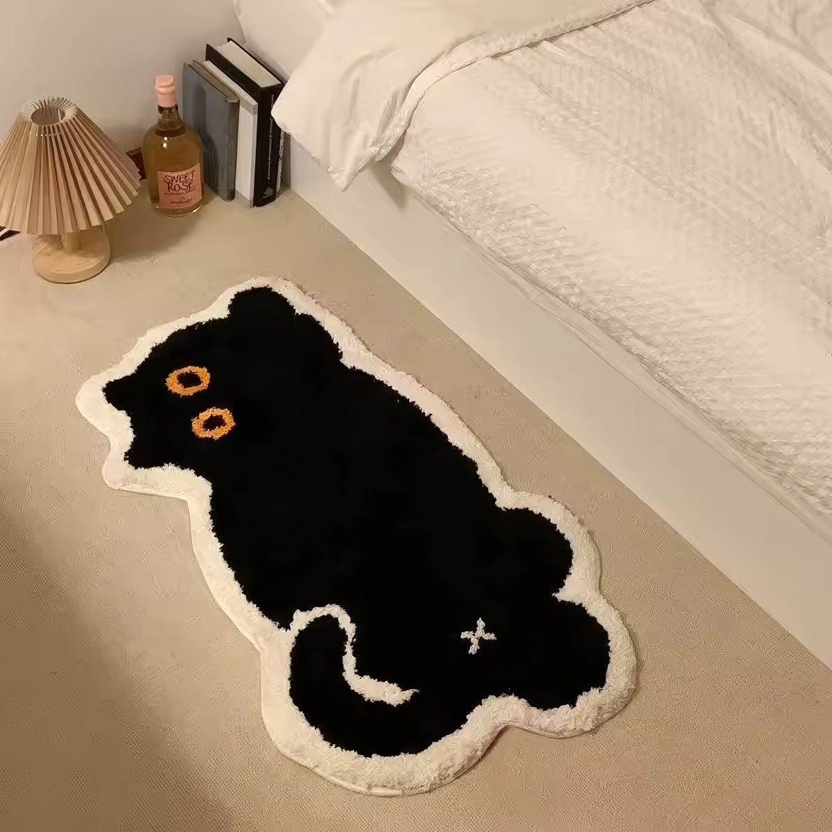 Black cat-shaped tufted rug with white border on a white background