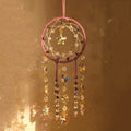 Crystal dreamcatcher wall hanging with prism beads, star charms, and sun-catching crystal strands in ivory and pink designs.