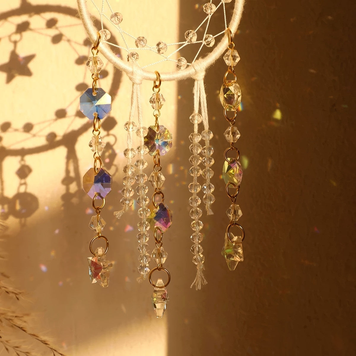 Crystal dreamcatcher wall hanging with prism beads, star charms, and sun-catching crystal strands in ivory and pink designs