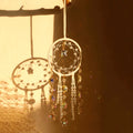 Crystal dreamcatcher wall hanging with prism beads, star charms, and sun-catching crystal strands in ivory and pink designs.