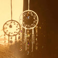 Crystal dreamcatcher wall hanging with prism beads, star charms, and sun-catching crystal strands in ivory and pink designs.