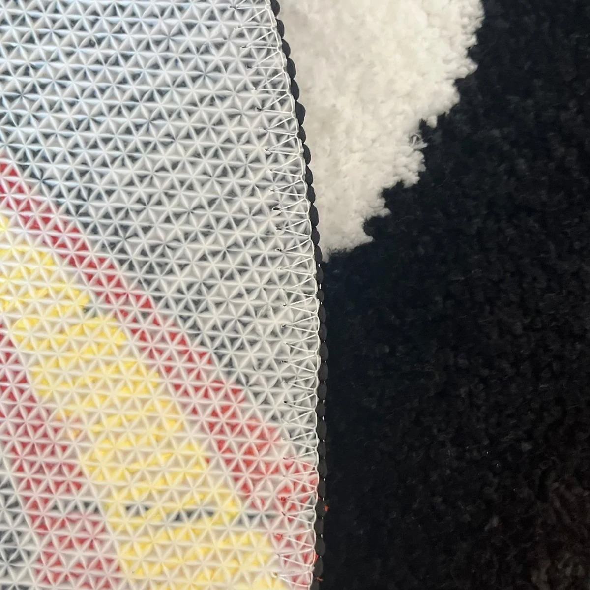 Round tufted rug with a black eight-ball design and red-yellow flame pattern.