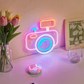camera-shaped wall neon sign with pastel pink and blue glowing