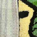 Tufted area rug designed as a stack of green dollar cash bills with a cream paper band