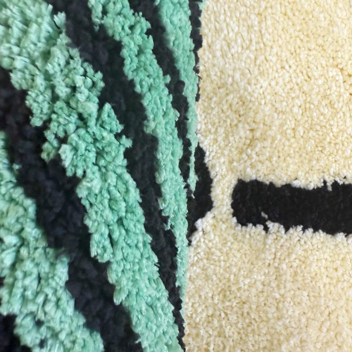 Tufted area rug designed as a stack of green dollar cash bills with a cream paper band