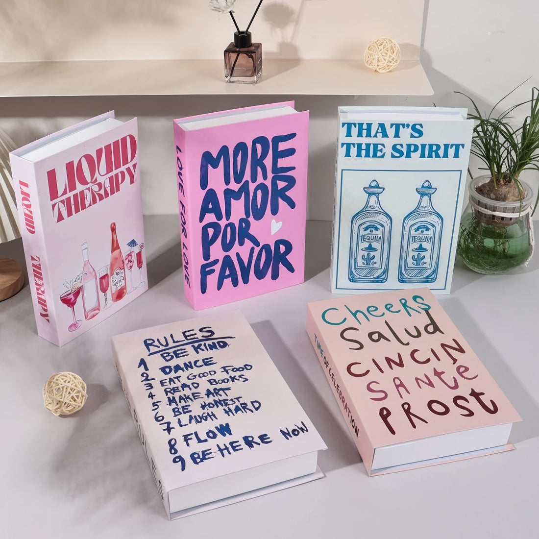 Decorative faux book storage box designed as a colorful hardcover book with a hidden storage compartment for organizing small household items while decorating shelves and tables
