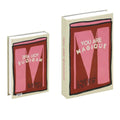 Decorative faux book storage box designed as a colorful hardcover book with a hidden storage compartment for organizing small household items while decorating shelves and tables