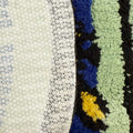 A tufted rug shaped like an arched window, displaying a blue sky with white clouds and a colorful bird on the sill