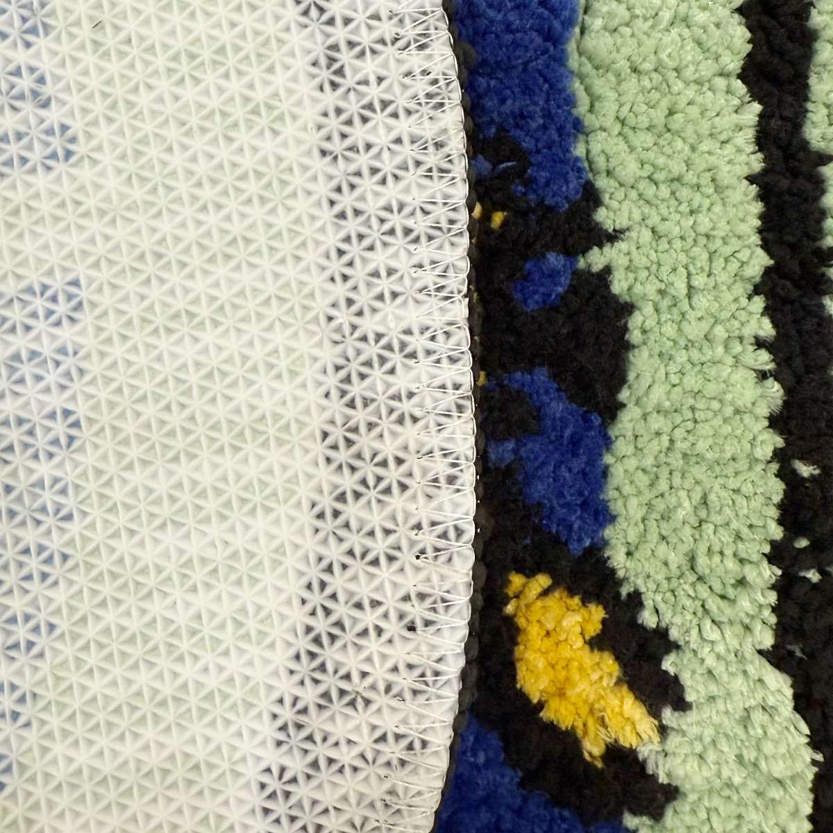 A tufted rug shaped like an arched window, displaying a blue sky with white clouds and a colorful bird on the sill