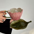 blooming pink flower shaped cup with green leaf shaped saucer