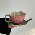 blooming pink flower shaped cup with green leaf shaped saucer