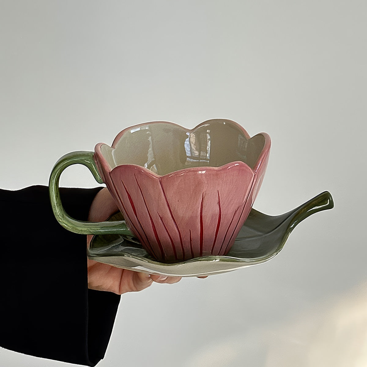 blooming pink flower shaped cup with green leaf shaped saucer