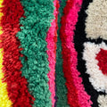 Colorful mushroom-shaped tufted rug with indie aesthetic, featuring vibrant stripes and plush texture