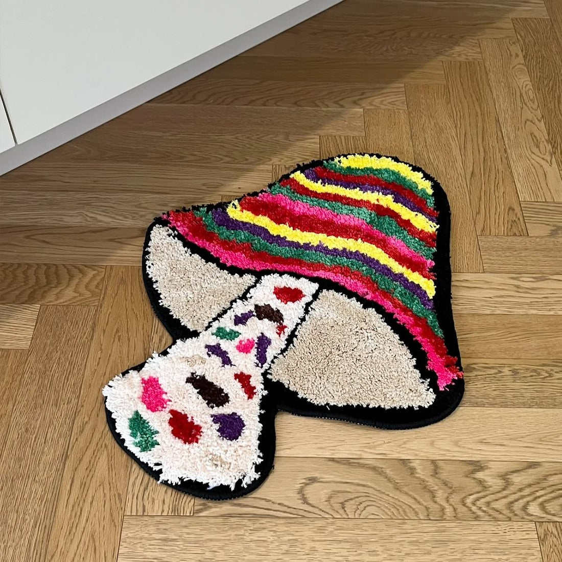 Colorful mushroom-shaped tufted rug with indie aesthetic, featuring vibrant stripes and plush texture