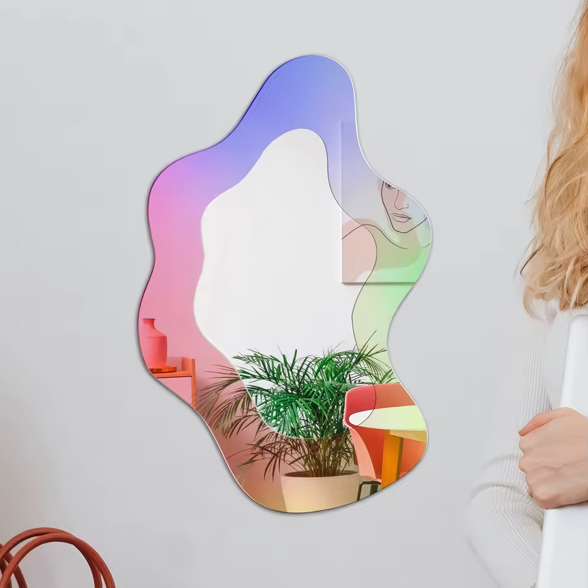 An abstract, wavy-edged acrylic mirror with a holographic iridescent finish that shifts between pink, purple, and light blue