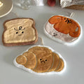 Plush kawaii hanging hand towel shaped like bread, croissant, toast, egg toast, and garlic with embroidered faces and hanging loops.