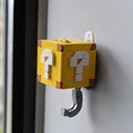 Two yellow block-style key hooks designed like Super Mario question blocks. Yellow Mystery Box hidden hook key holder with white question mark design