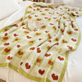 Heart-patterned blanket draped over a bed