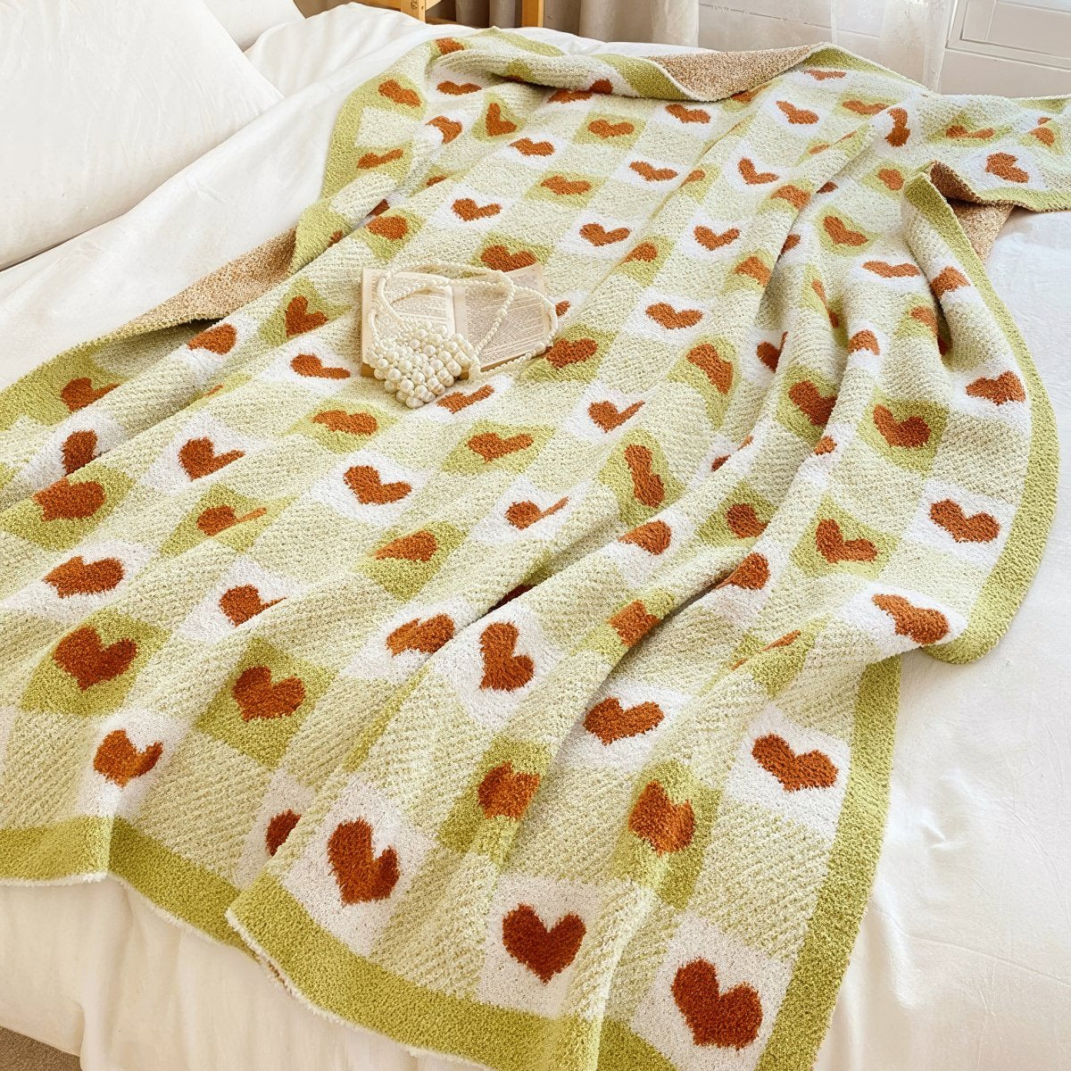 Heart-patterned blanket draped over a bed
