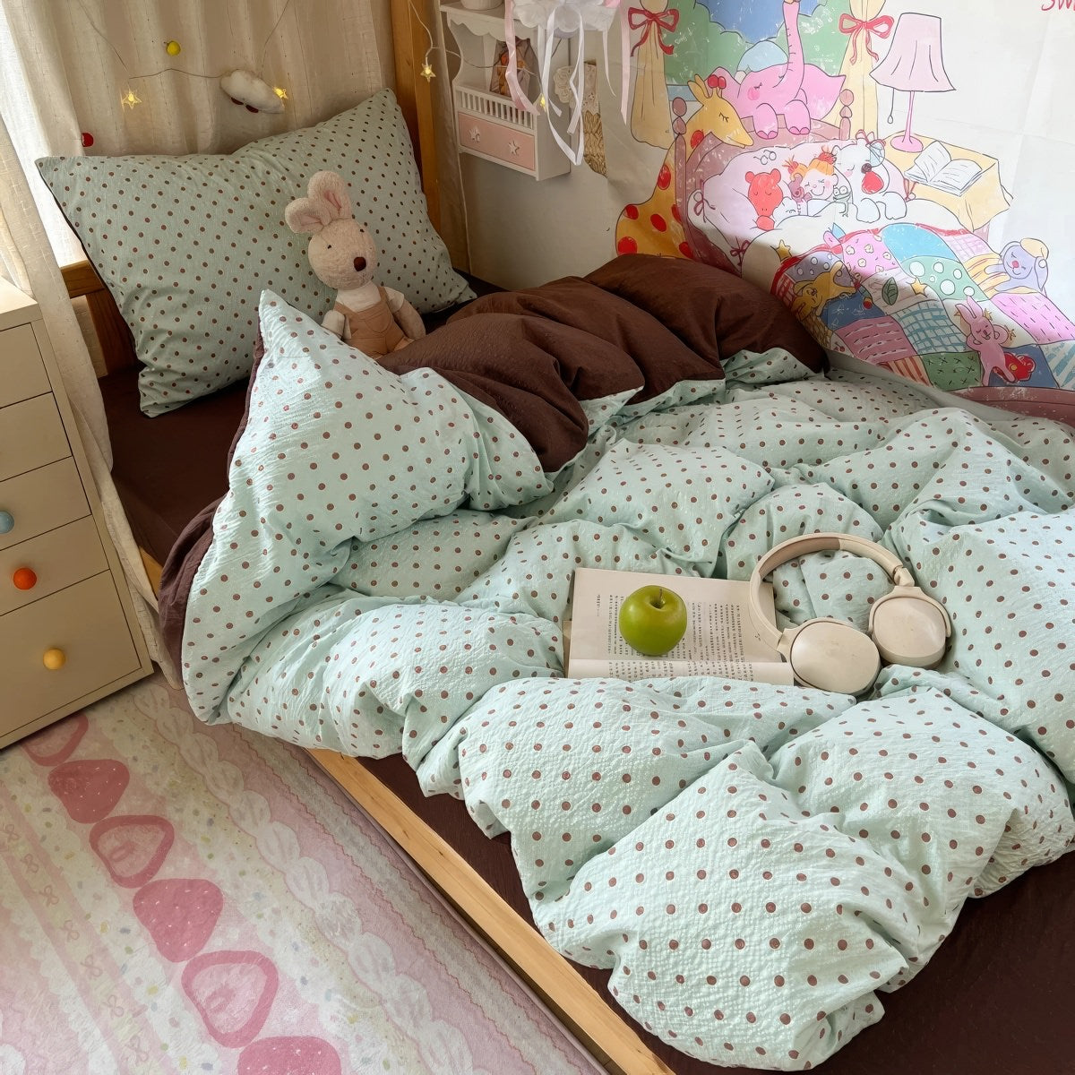 Mint green bubble crinkle bedding set with brown polka dots on a cozy bedroom bed