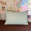 Mint green bubble crinkle bedding set with brown polka dots on a cozy bedroom bed