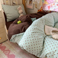 Mint green bubble crinkle bedding set with brown polka dots on a cozy bedroom bed