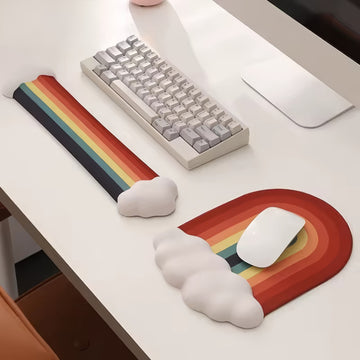 A rainbow-themed ergonomic wrist rest set, including a cloud-cushioned mouse pad and a matching keyboard wrist support, designed with a gradient rainbow pattern and soft white cloud accents