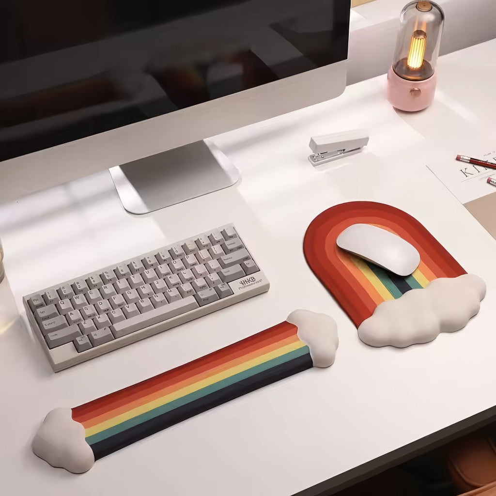 A rainbow-themed ergonomic wrist rest set, including a cloud-cushioned mouse pad and a matching keyboard wrist support, designed with a gradient rainbow pattern and soft white cloud accents