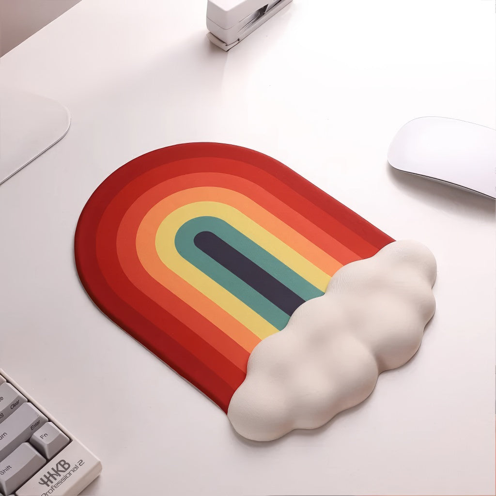 A rainbow-themed ergonomic wrist rest set, including a cloud-cushioned mouse pad and a matching keyboard wrist support, designed with a gradient rainbow pattern and soft white cloud accents