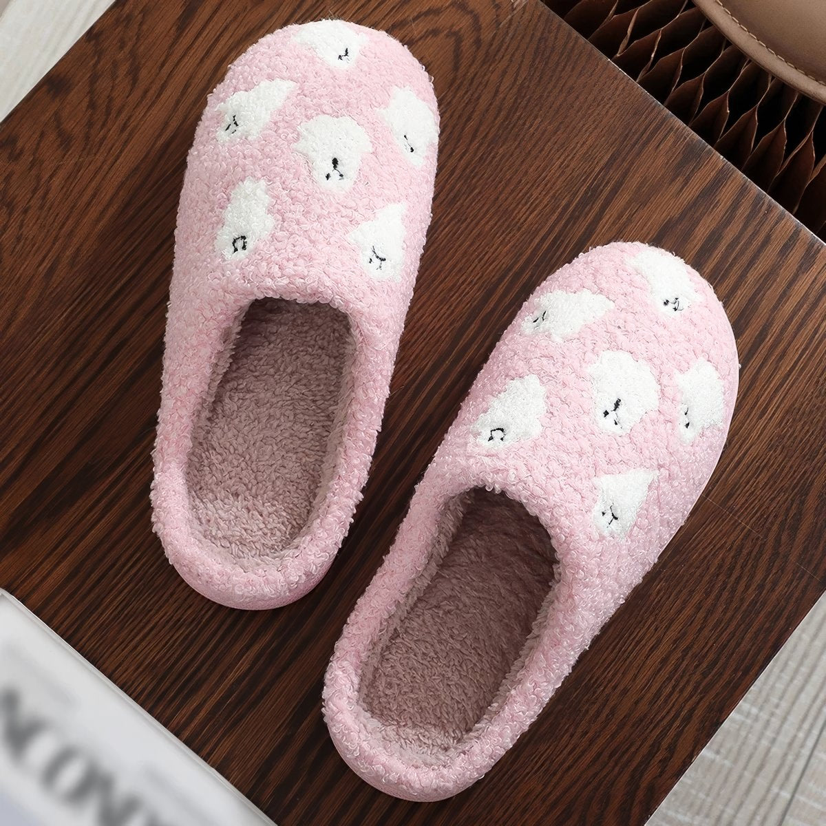 Plush pink ghost slippers with white ghost patterns and soft fuzzy lining