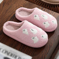 Plush pink ghost slippers with white ghost patterns and soft fuzzy lining