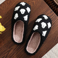 Plush black ghost slippers with white ghost patterns and soft fuzzy lining