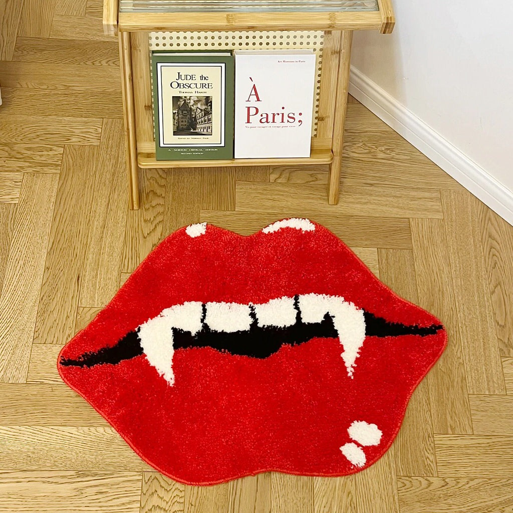 aesthetic accent tufted rug in the shape of red lips with an open mouth, featuring white vampire fangs and black shading inside the mouth