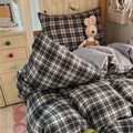 Black and brown plaid bubble crinkle bedding set with matching pillows on a cozy bedroom bed