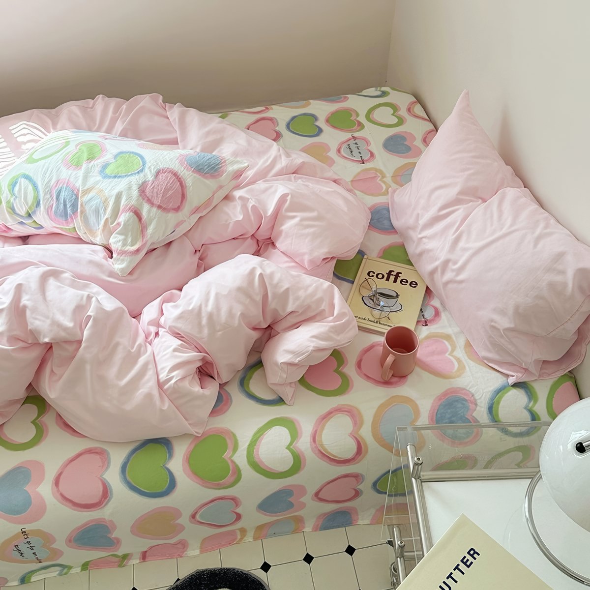 bedding set with pink comforter and heart-patterned sheets in y2k aesthetic