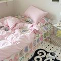 bedding set with pink comforter and heart-patterned sheets in y2k aesthetic
