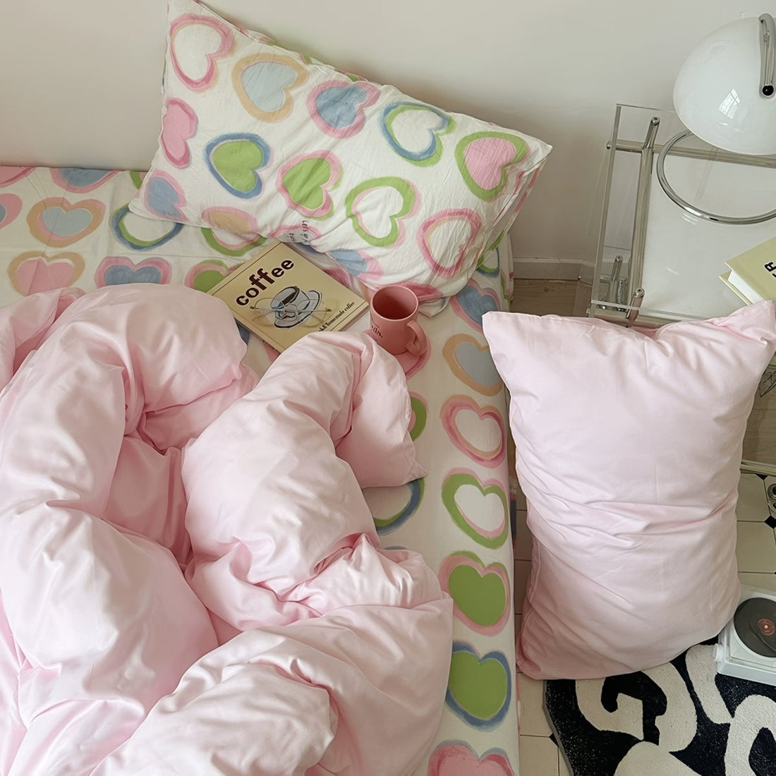 bedding set with pink comforter and heart-patterned sheets in y2k aesthetic